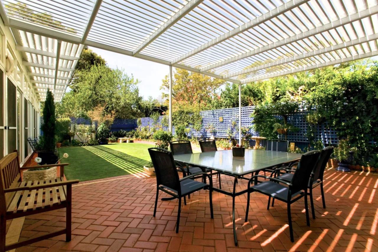 White slatted pergola shading a brick-paved outdoor dining setting — Miranda, NSW