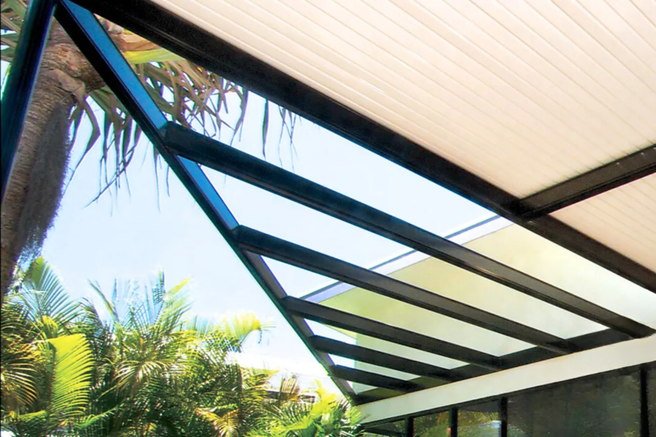 Glass-roof pergola with powder-coated steel beams over a tropical alfresco — Wollongong, NSW